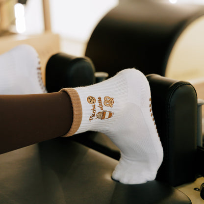 White socks with brown mocha latte, cookie, pretzel cute graphic design on a Pilates reformer.